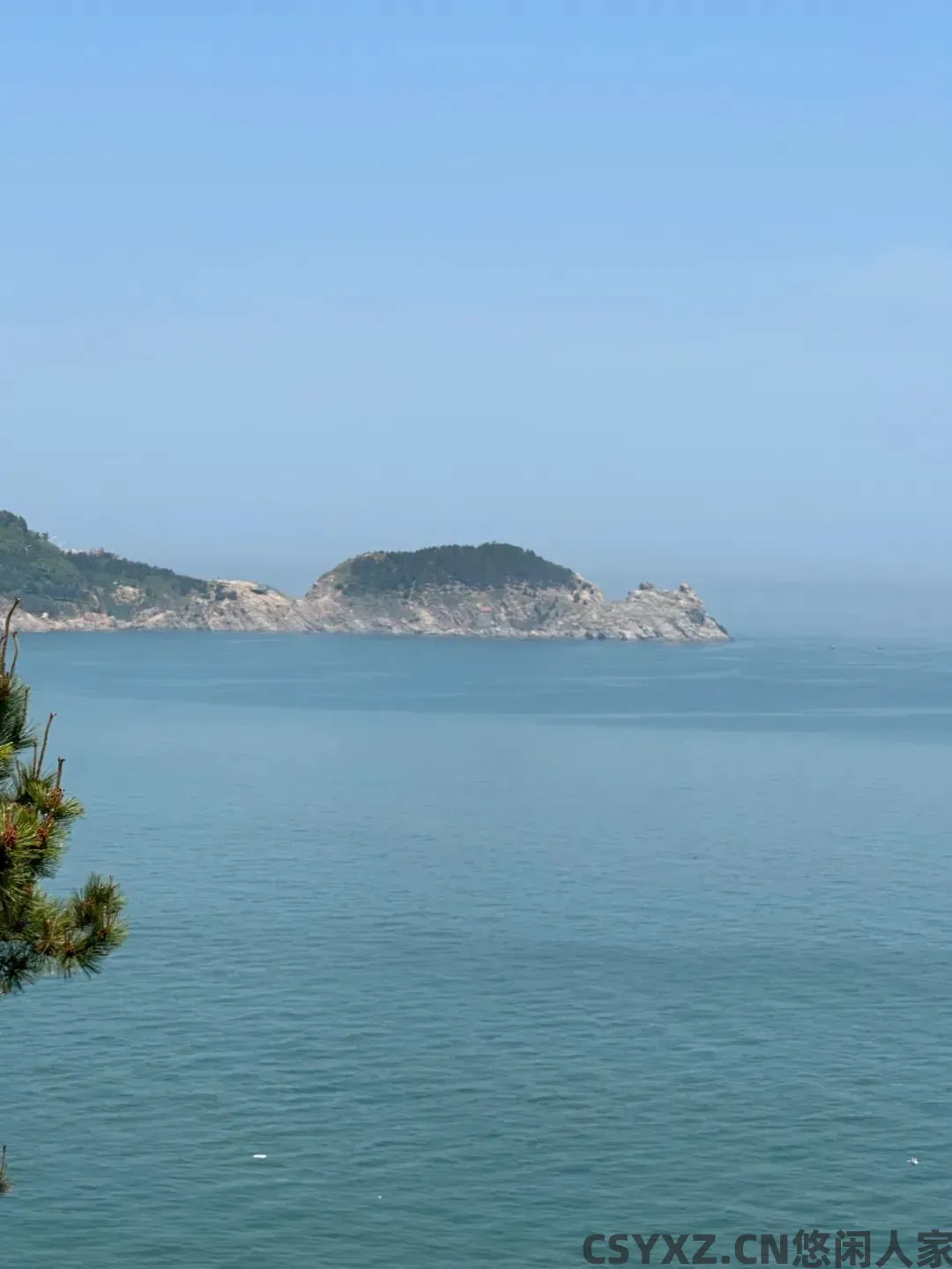 △站在礁石上，可以看到猫头山宛若卧猫般趴在海里。（图/简墨 摄）